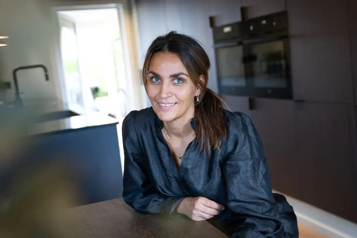 Anita Tonby ved kjøkkenøya i det nye kjøkkenet med mørke eikefronter